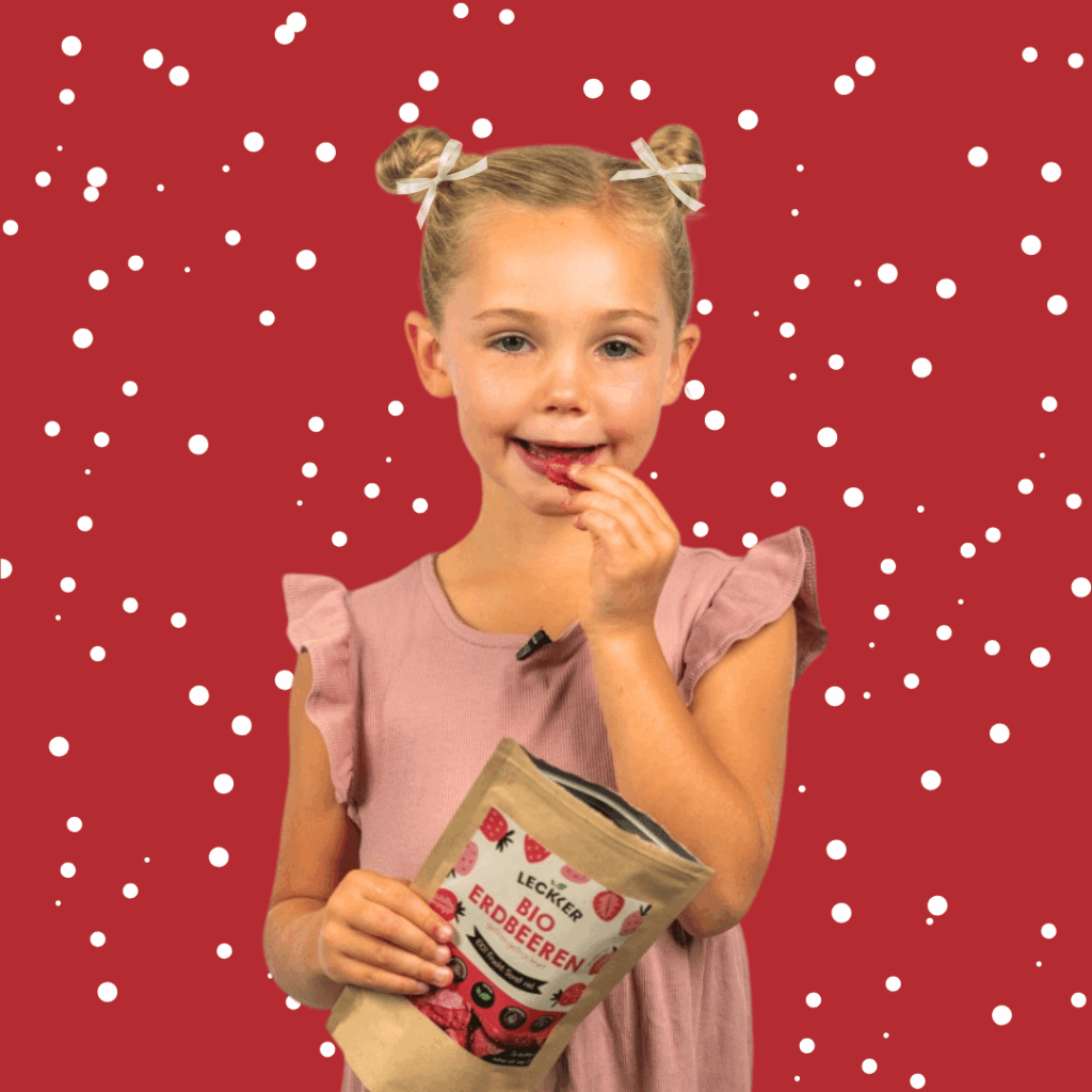 Kind sitzt in der Küche mit gefriergetrockneten Himbeeren