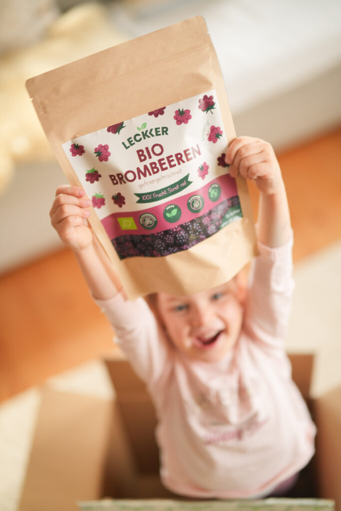 Mann und Frau mit gefriergetrockneten Brombeeren