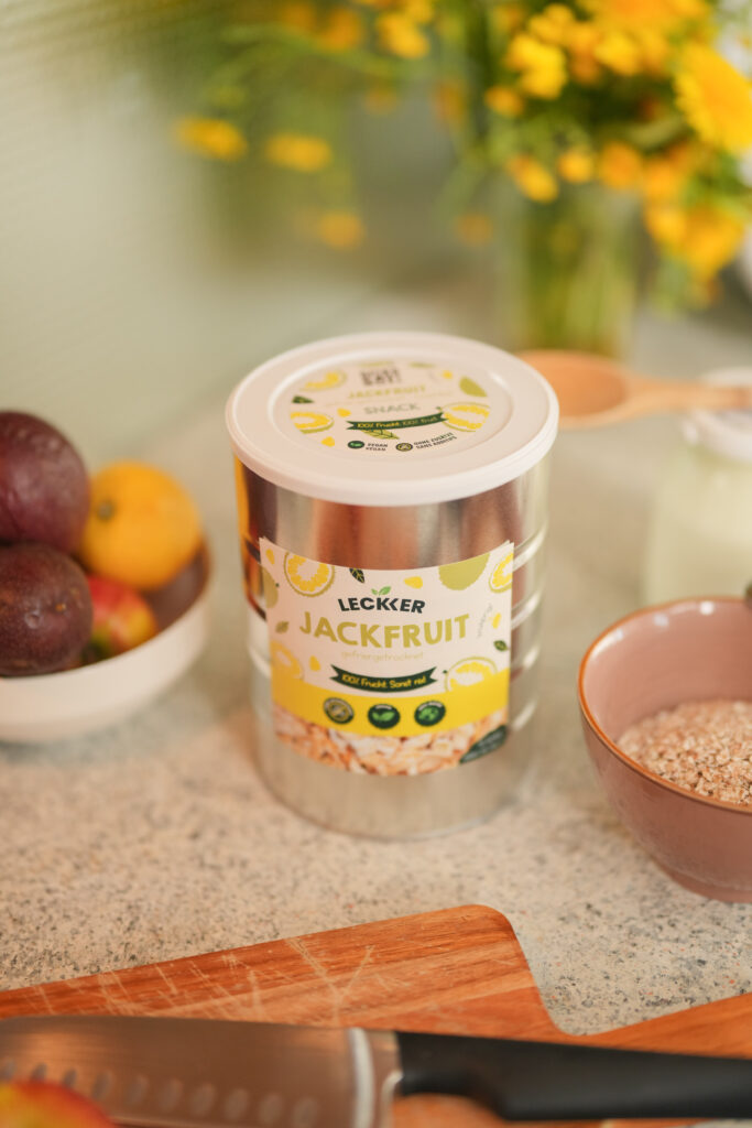 Kind sitzt in der Küche mit gefriergetrockneten Himbeeren